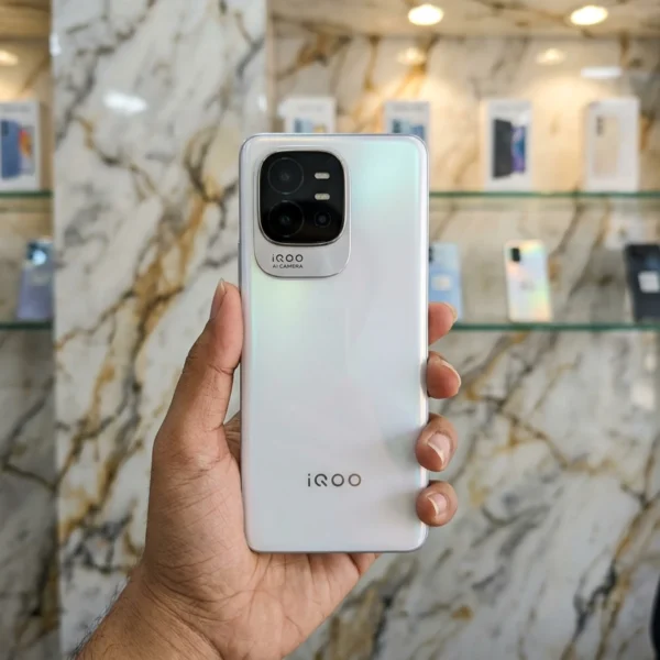 iQOO Z11 Turbo Pearl White front panel displaying lock screen held in hand inside mobile store