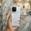 iQOO Z11 Turbo Pearl White front panel displaying lock screen held in hand inside mobile store